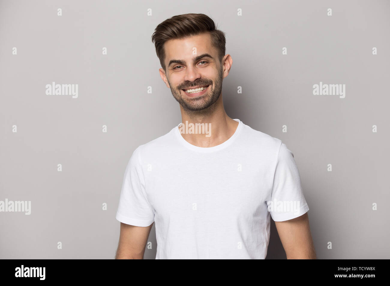 Positivo atractivo chico con blanco-nieve sonrisa mirando a la cámara Foto de stock