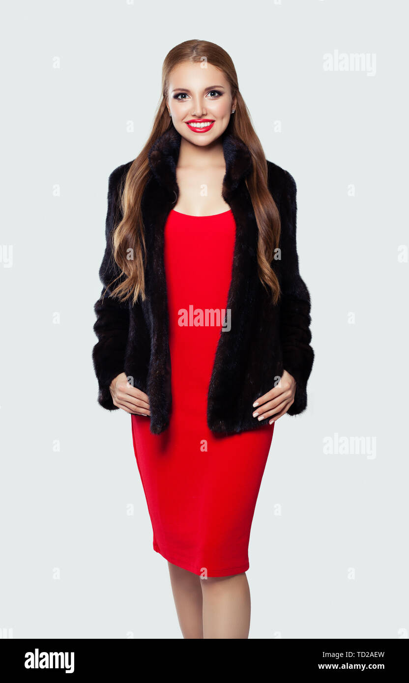 Mujer feliz en el vestido rojo y abrigo negro sobre blanco, moda retrato Fotografía de - Alamy