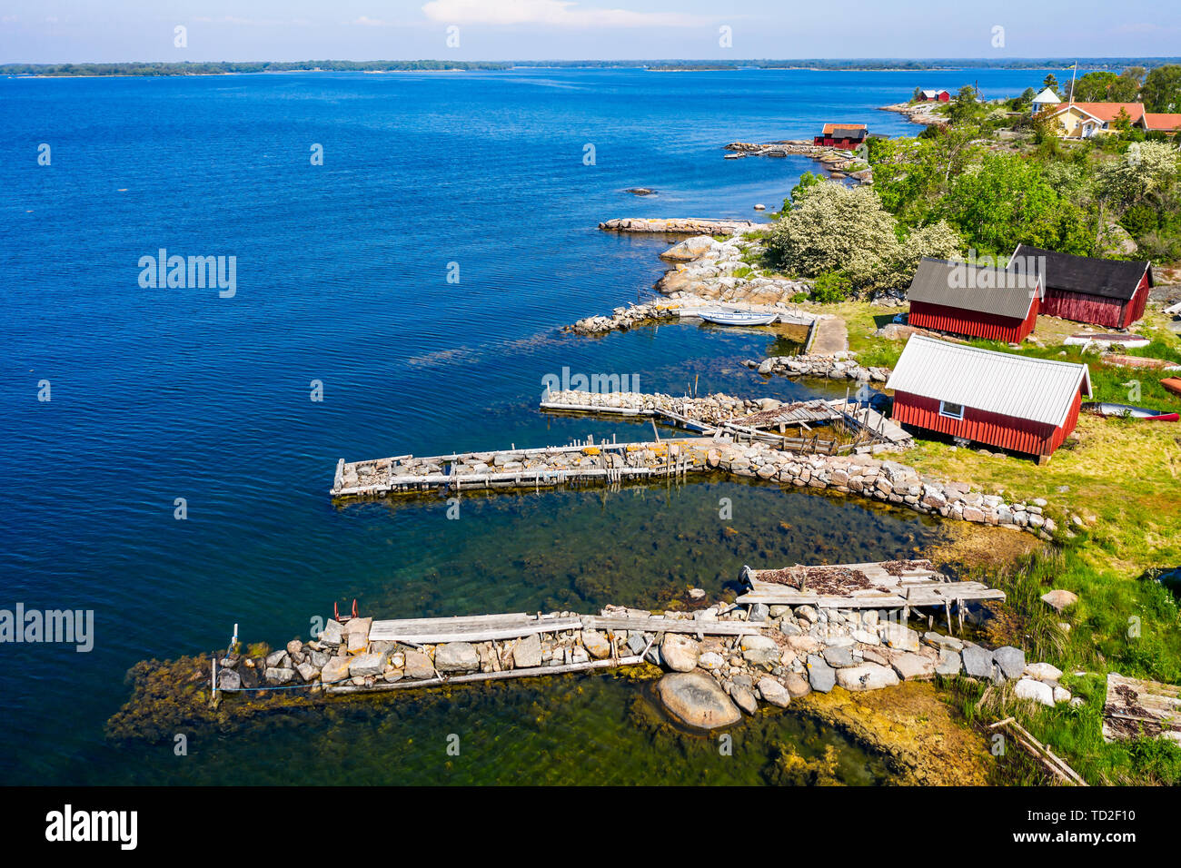 Campamento de pesca tradicional, típico de la costa sueca con embarcaderos de piedra y de madera pequeños cobertizos de pesca. Ubicación Isla Hasslo en Blekinge archipela Foto de stock