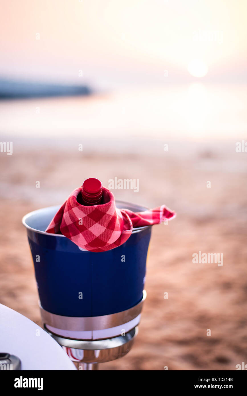 Botella de vino en una playa refrigerada para una cena romántica Foto de stock