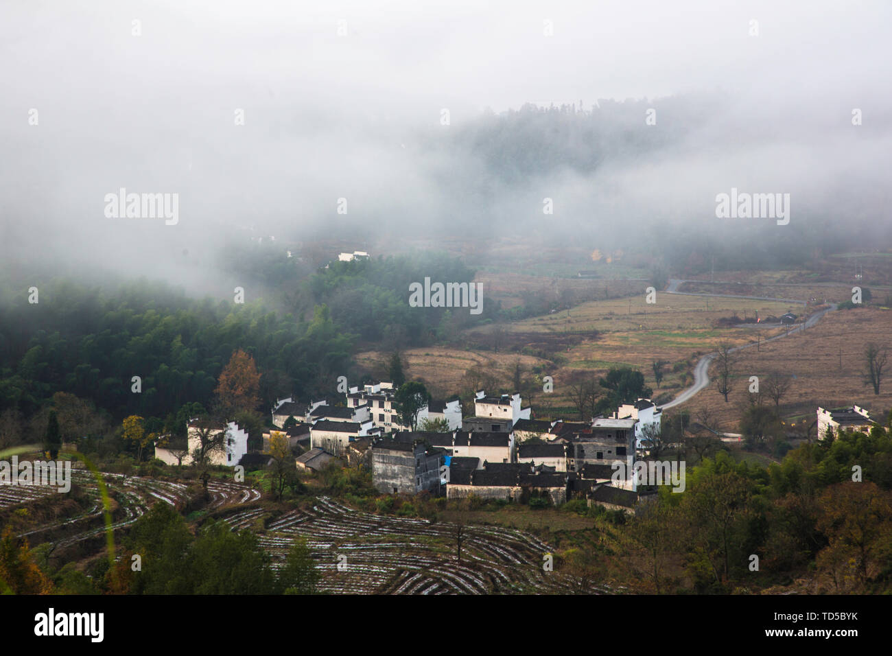 Una antigua aldea envuelto por las nubes y la niebla. Foto de stock