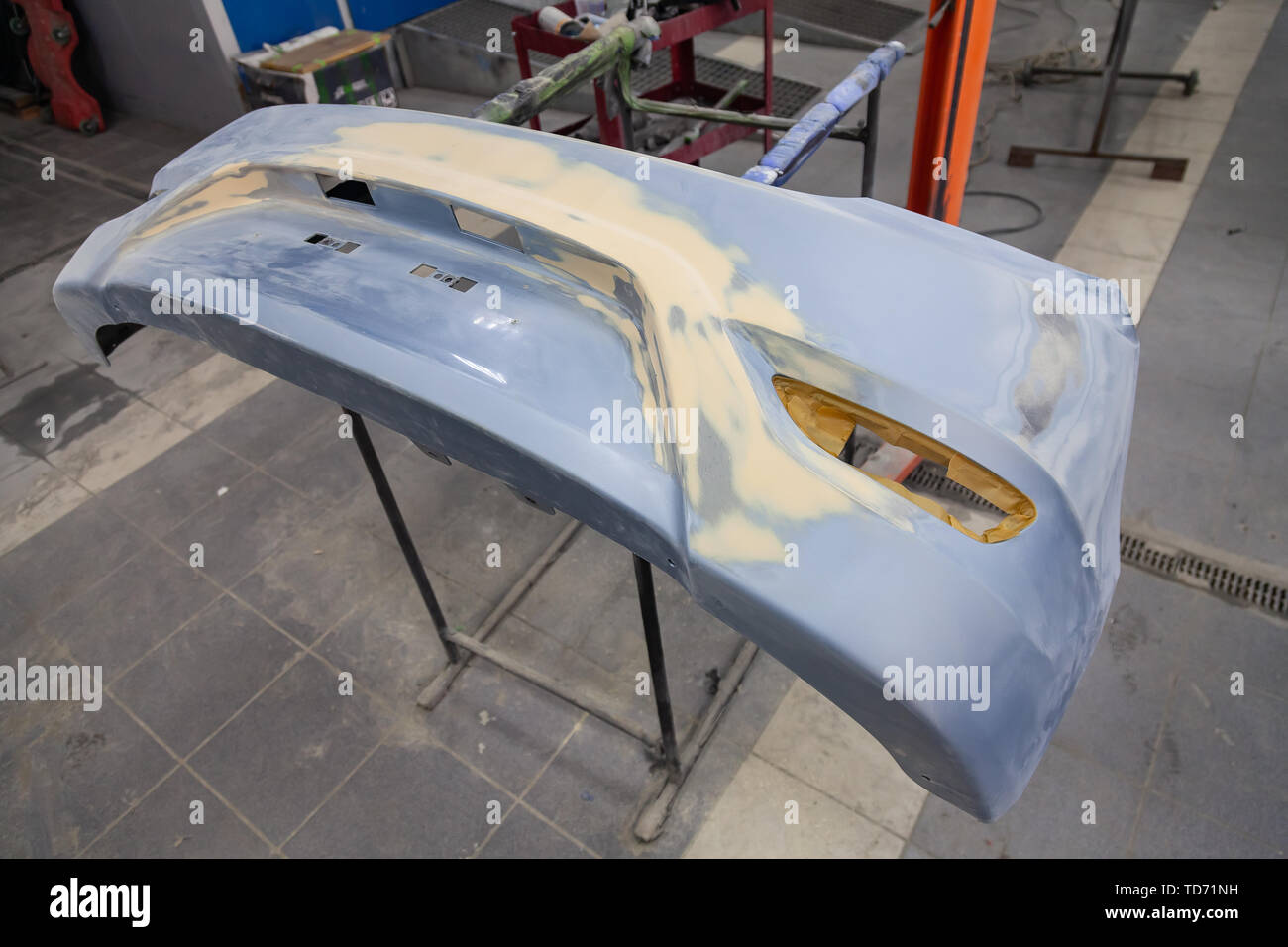La reparación del parachoques trasero de un coche azul después de un  accidente con la ayuda de múltiples colores putty en un taller de pintura  de vehículos en un especial chambe Fotografía