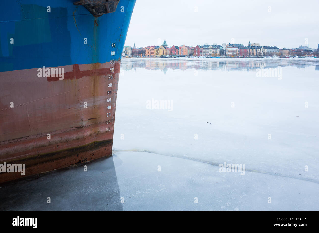 Vista invernal de Kungsholmen de Estocolmo, mirando a través del lago congelado con barcos amarrados en el primer plano. Foto de stock