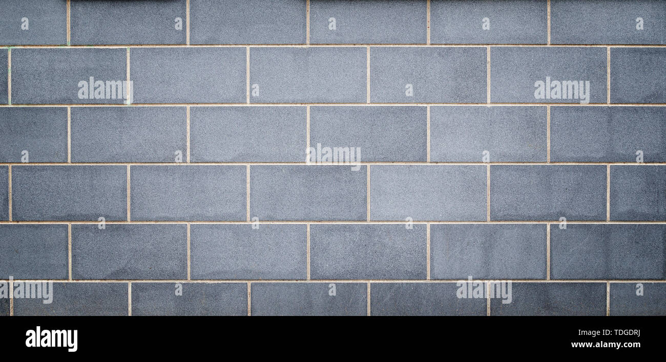 Alta resolución full frame de un fondo limpio y nuevo edificio o pared exterior fabricado de losas de piedra gris claro azulado. El viñeteado y copie el espacio. Foto de stock