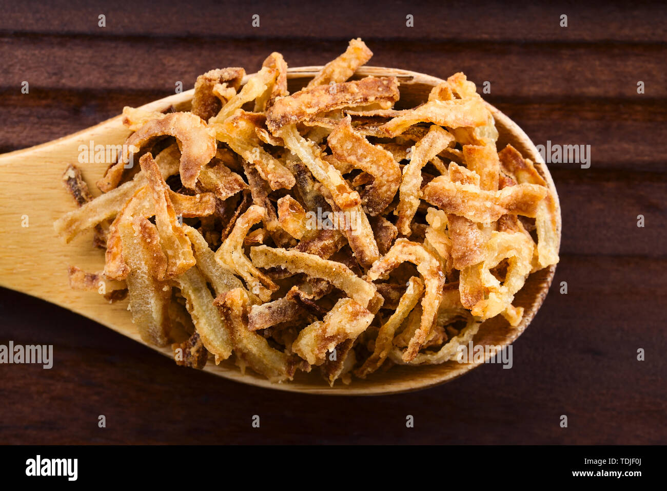 Casera dulce de cebolla frita crujiente cadenas en la cuchara de madera,  fotografió la sobrecarga (el enfoque selectivo, se centran en las  principales cadenas de cebolla Fotografía de stock - Alamy