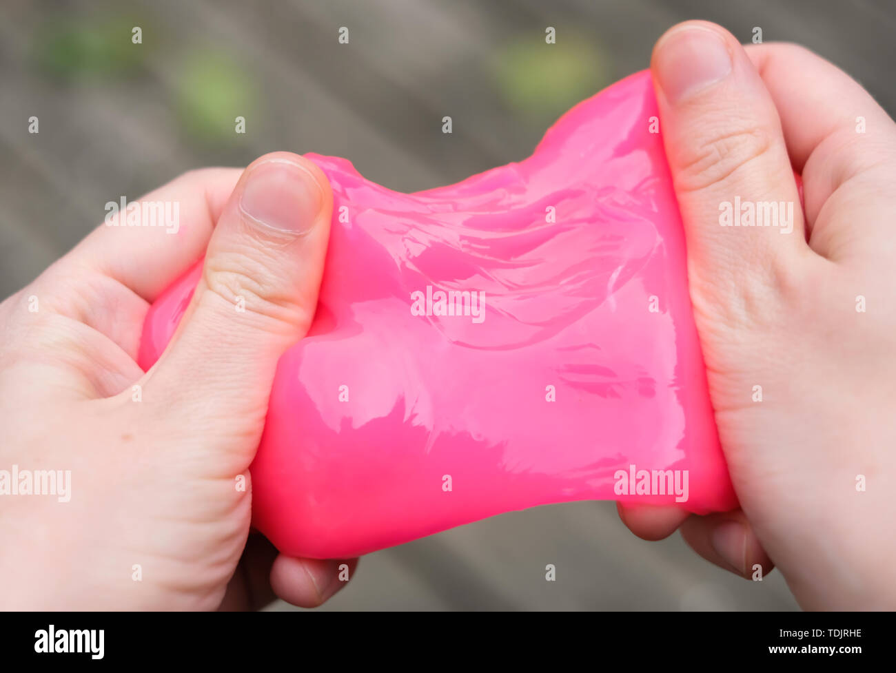 Rosa juguete antiestrés limo en las manos. Luchando contra la ansiedad y el estrés. Juego creativo experimento para los niños. Foto de stock