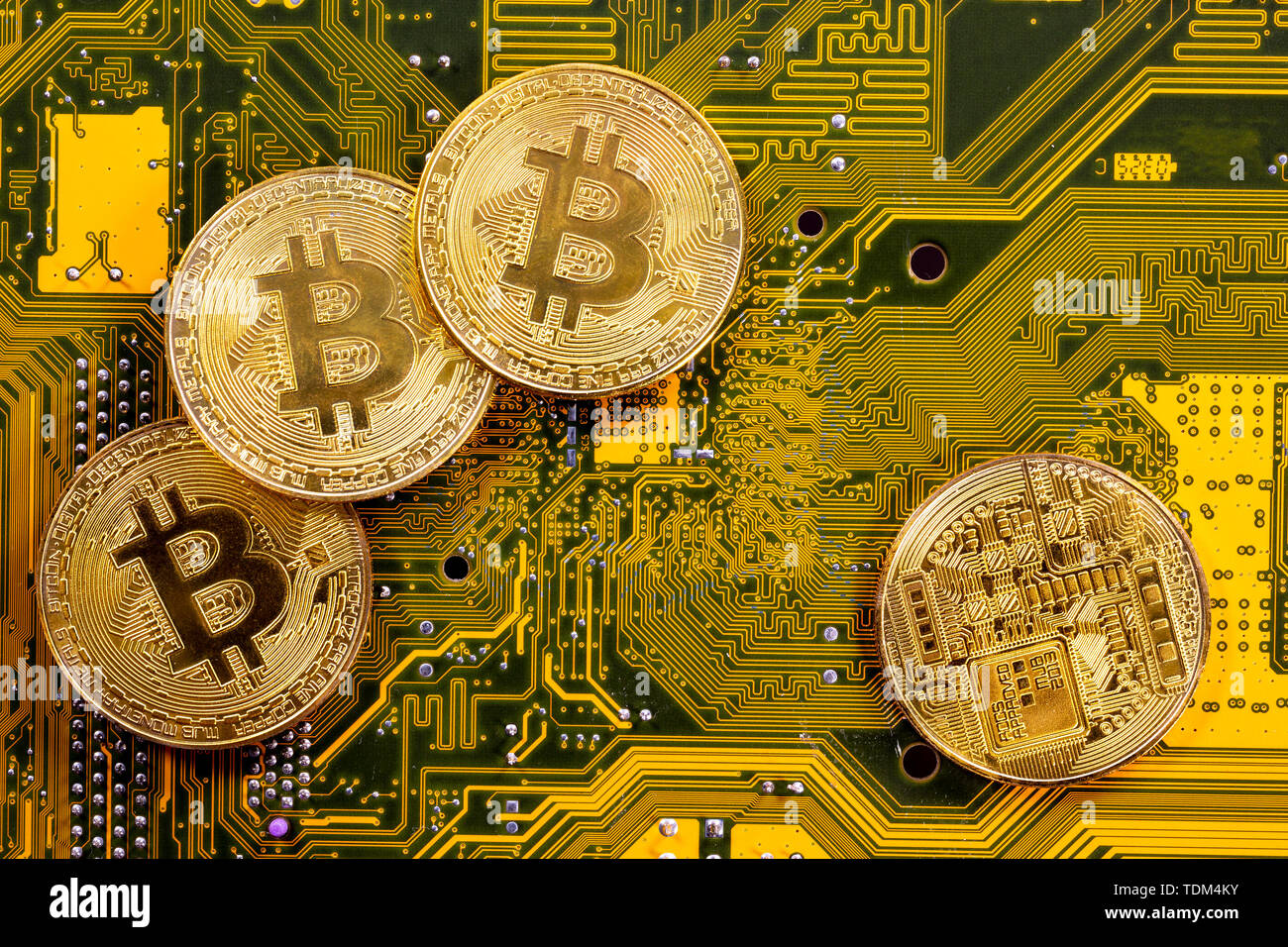 Dinero cryptocurrency Virtual Bitcoin monedas de oro en un equipo en el circuito impreso de la PCB. El futuro del dinero. Equipamiento computacional. Amarillo y gr Foto de stock