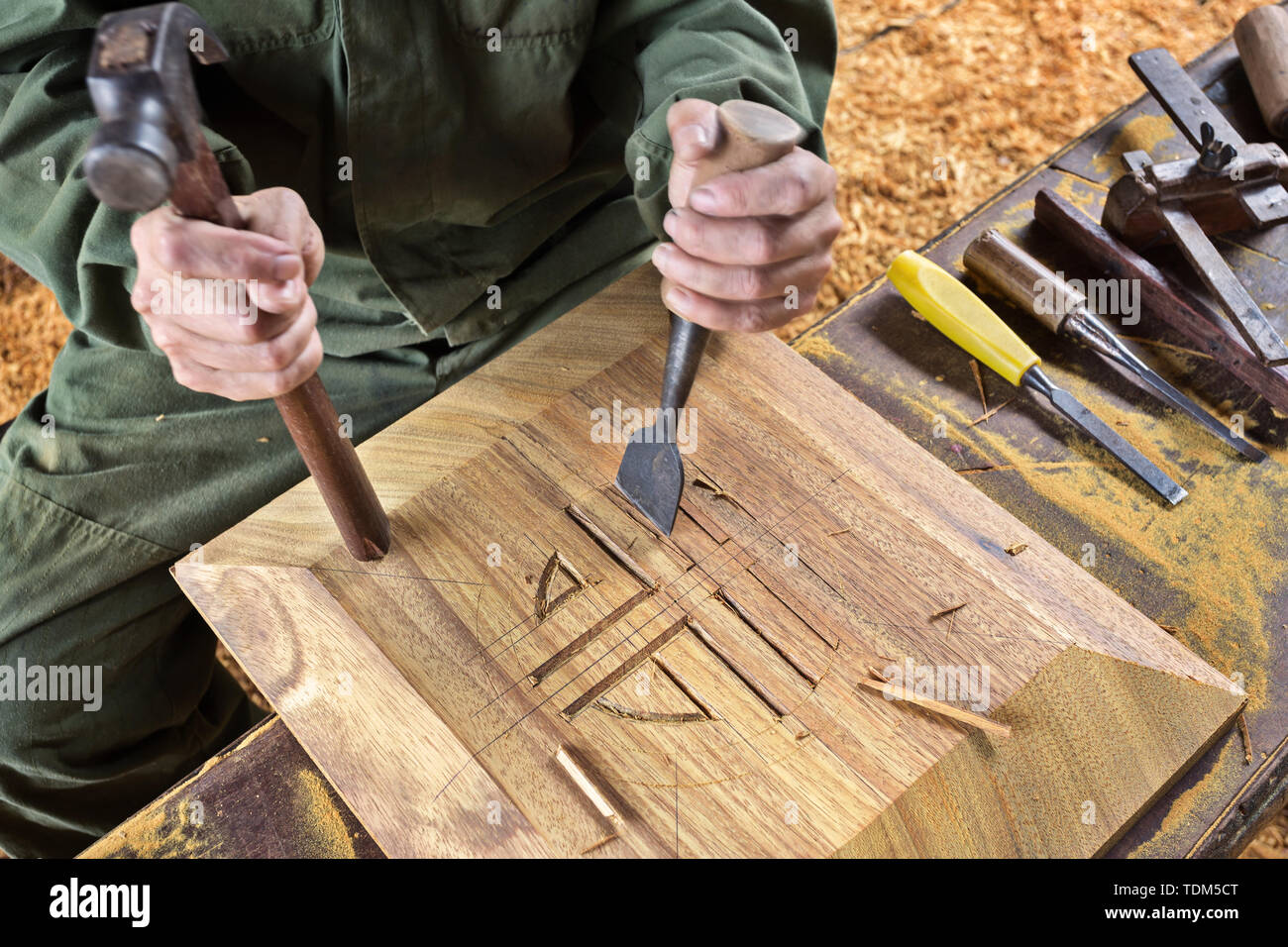 Cincel para madera carpintero herramienta martillo en mano de trabajo antecedentes de madera Fotografía stock - Alamy