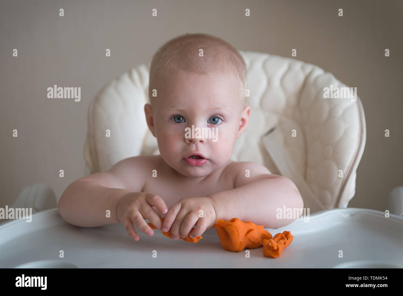 Los niños creatividad. El bebé está intentando esculpir de arcilla naranja.  Cute little boy el molde de plastilina en la mesa Fotografía de stock -  Alamy