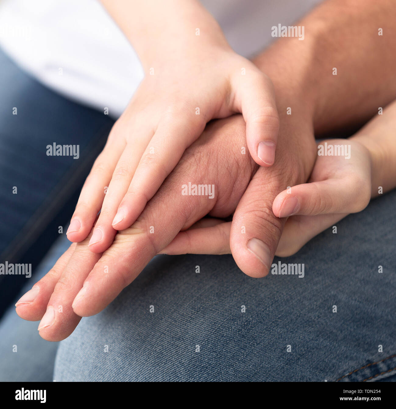 La pequeña niña calentando su papá manos, closeup Foto de stock