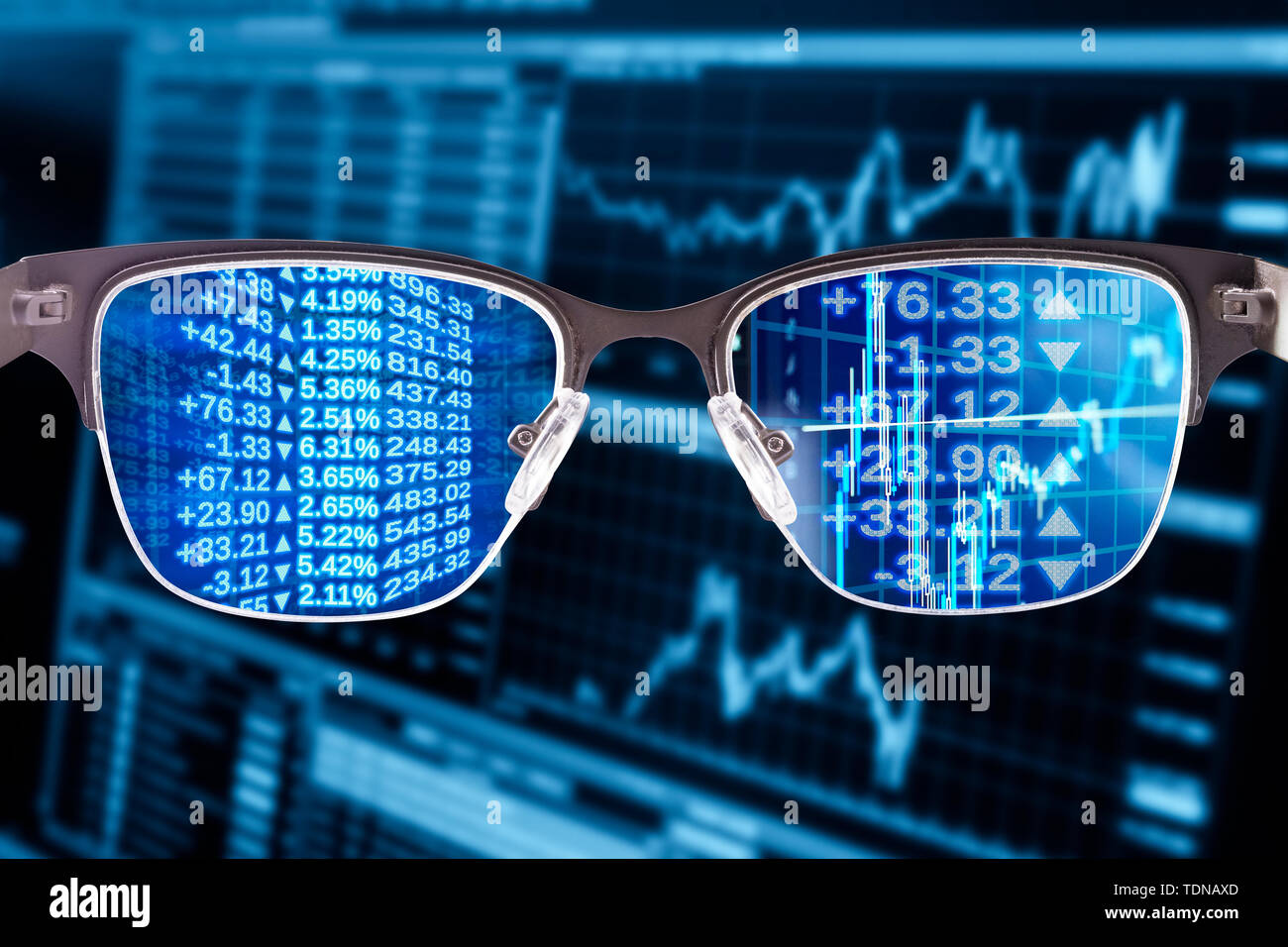 Gafas con datos financieros y monitor en el fondo Foto de stock