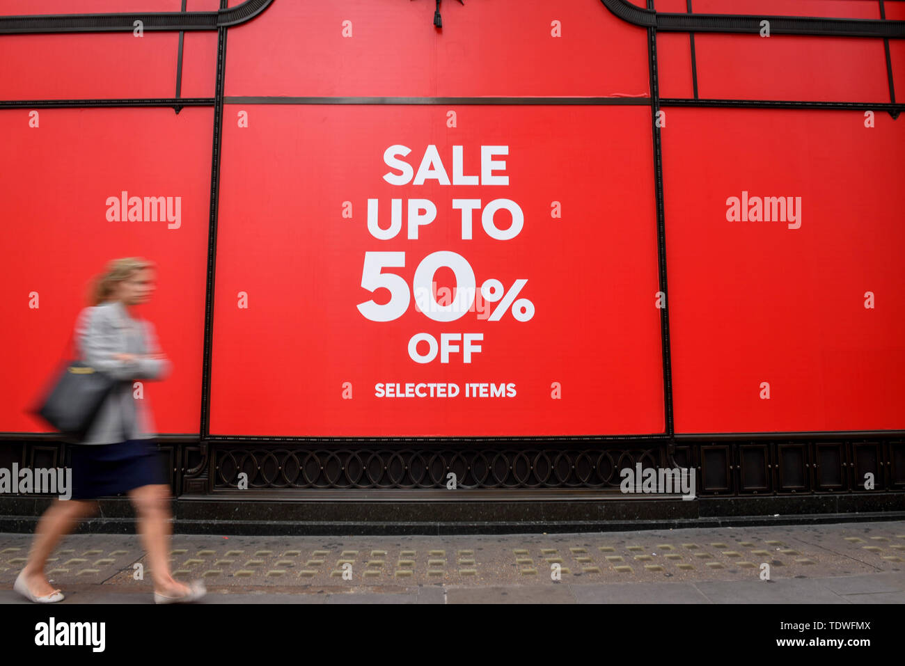 Londres, Reino Unido. 19 de junio de 2019. Una mujer pasa por una tienda en  Regent Street como las rebajas de verano empieza la temporada, con muchas  tiendas ofrecen grandes descuentos para