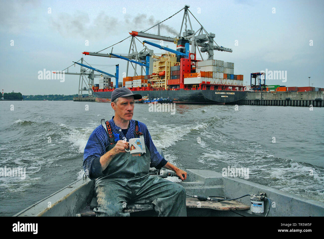 Fischerman en un barco de pesca en el río Elba en el puerto de Hamburgo, Alemania, Hamburgo Foto de stock