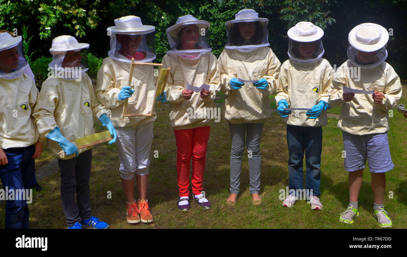 Los apicultores junior, alumnos con sombreros del apicultor, alambradas de protección y herramientas de trabajo, Alemania Foto de stock