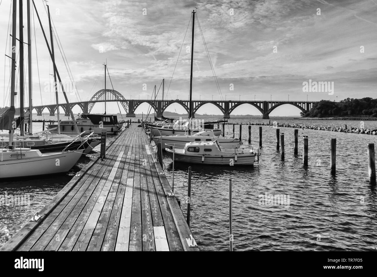 Paisajes en blanco y negro de la marina de Kalvehave, Dinamarca con el famoso puente de Moen en el fondo Foto de stock