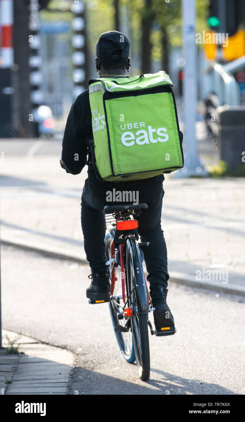 Amsterdam, Países Bajos, mensajeros del servicio de entrega de comestibles online Uber come, proveedor de bicicletas y servicio de mensajería a pie. Foto de stock
