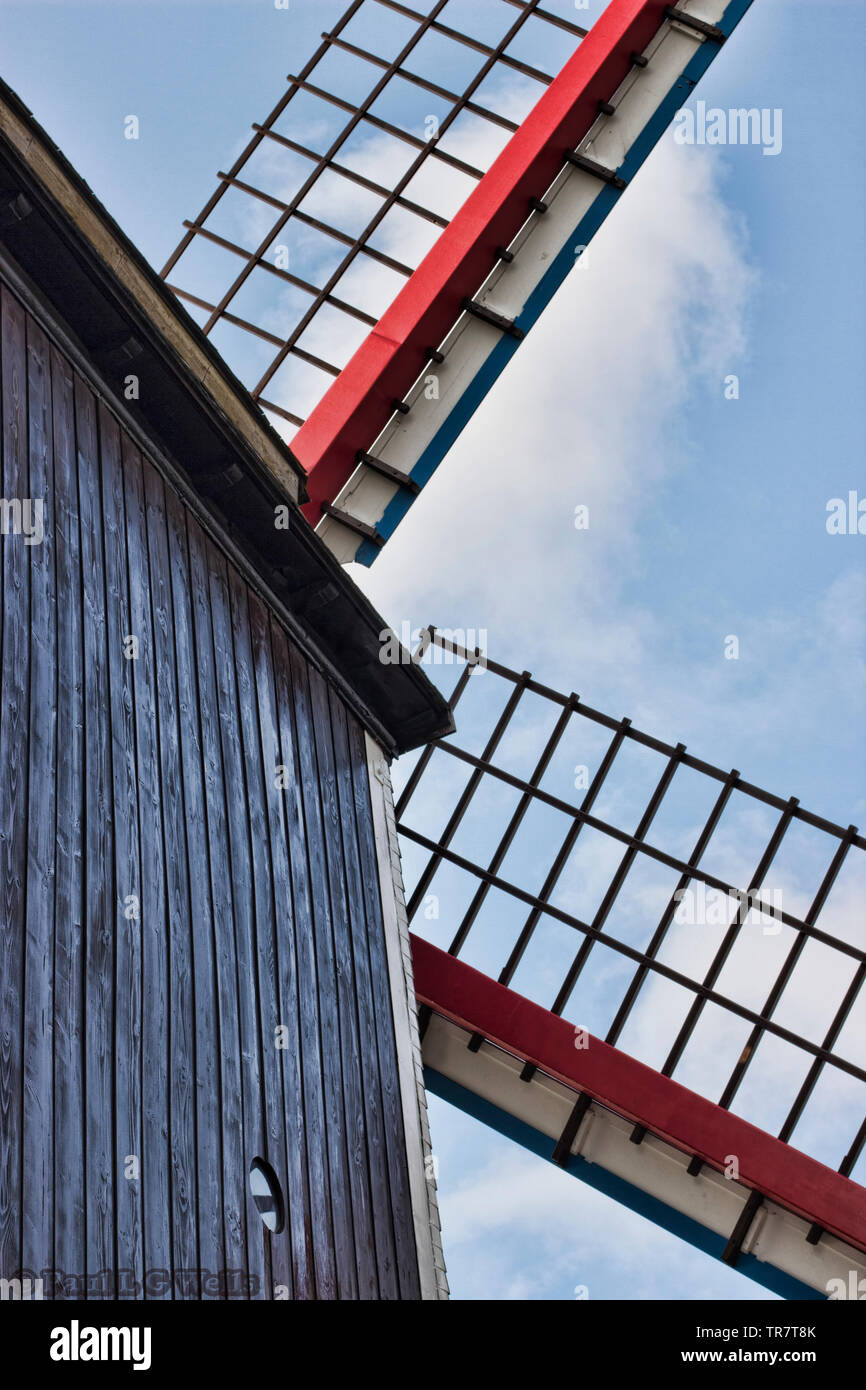 Imagen en color que muestra una vista de un molino de viento construyendo desde un ángulo inusual incluyendo el edificio de madera mas piezas ot las velas Foto de stock