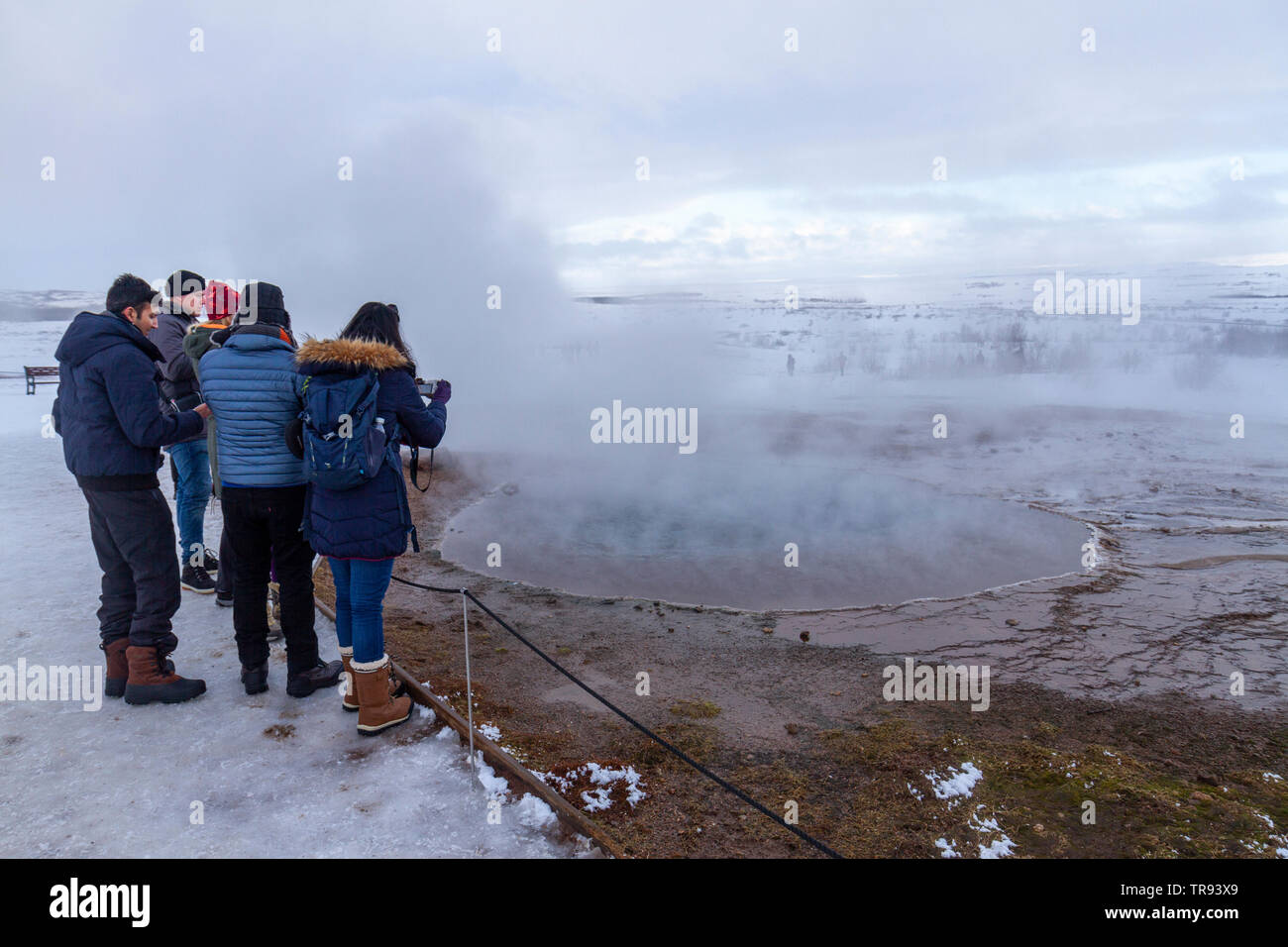 Los visitantes cerca de una de las piscinas termales en el Geysir Hot Springs campo geotérmico, parte del círculo de oro de Islandia. Foto de stock