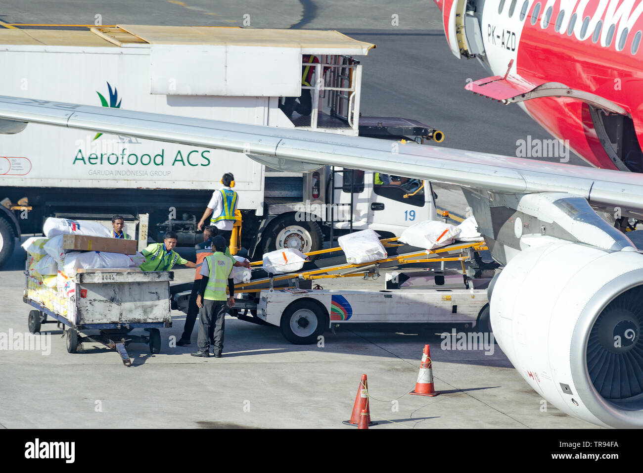 Bali, Denpasar, 2018-05-01: los trabajadores del aeropuerto de carga suministros de catering en los aviones. El personal de tierra pone el embalaje con alimentos de ACS Aerofood Foto de stock