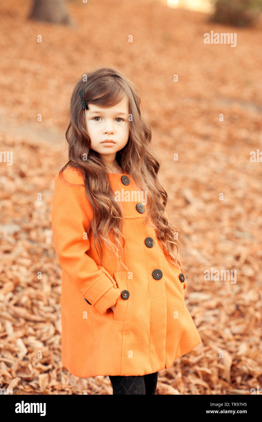 Elegante niña 4-5 años de caminar en el parque. Llevar abrigo de moda.  Posando al aire libre. Mirando a la cámara Fotografía de stock - Alamy