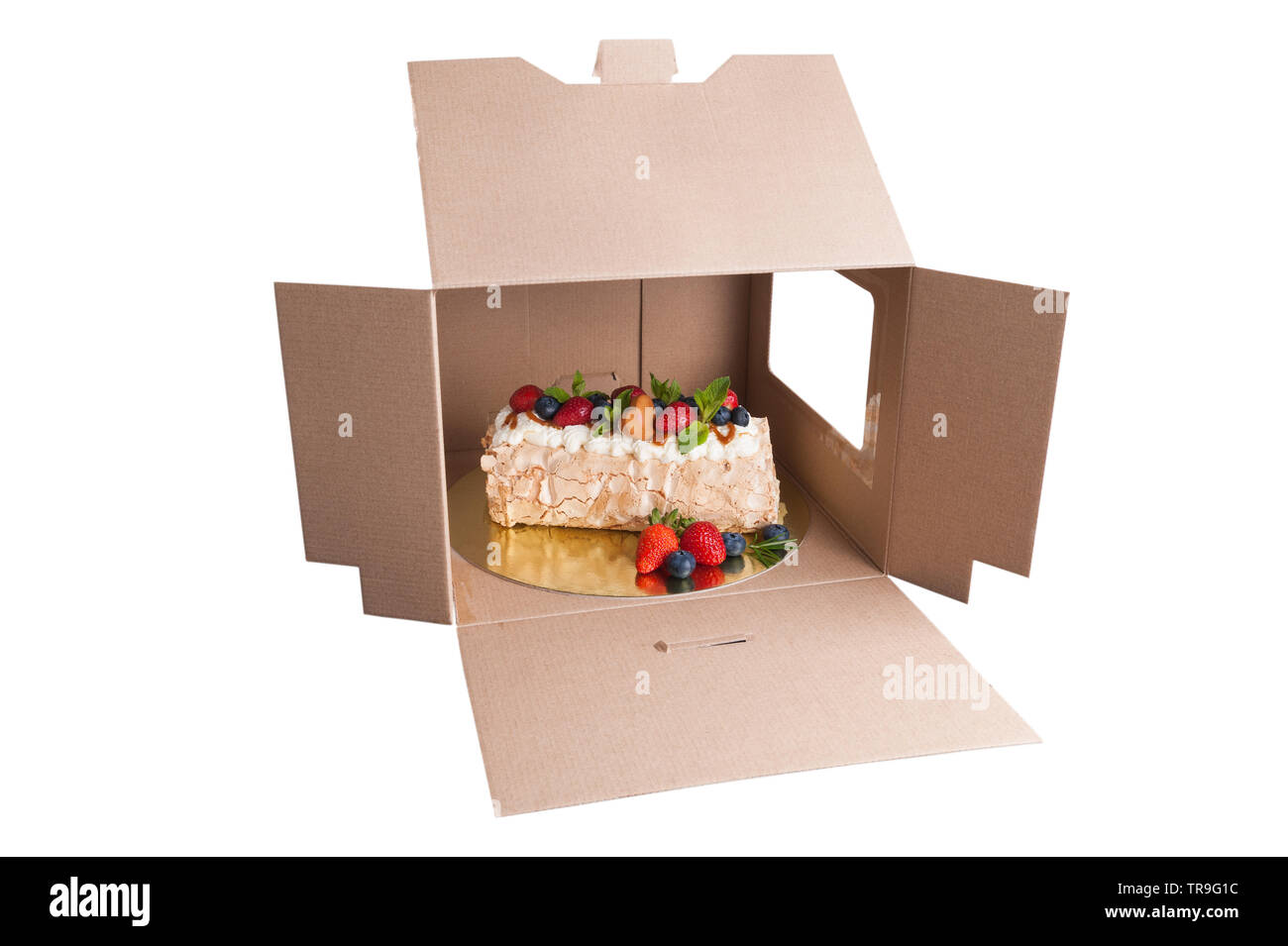 Bizcocho con bayas en una caja de cartón aislado Foto de stock