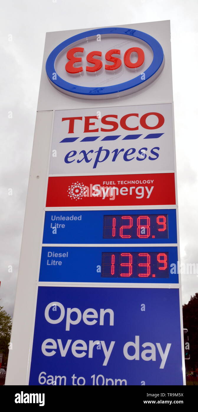 Cartel que muestra los precios de la gasolina en un garaje Tesco Express con la Marca Esso en Ardwick, Manchester, reino unido Foto de stock
