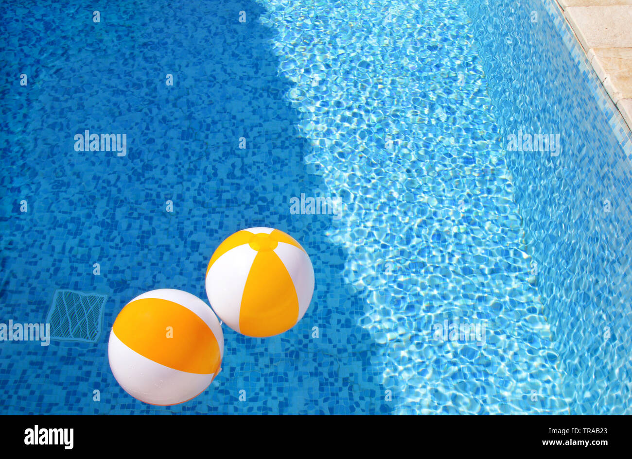 Dos de aire de caucho blanco amarillo bolas y juguetes inflables para la  piscina de agua azul transparente. Pelotas de playa multicolor flotando  sobre el agua Fotografía de stock - Alamy