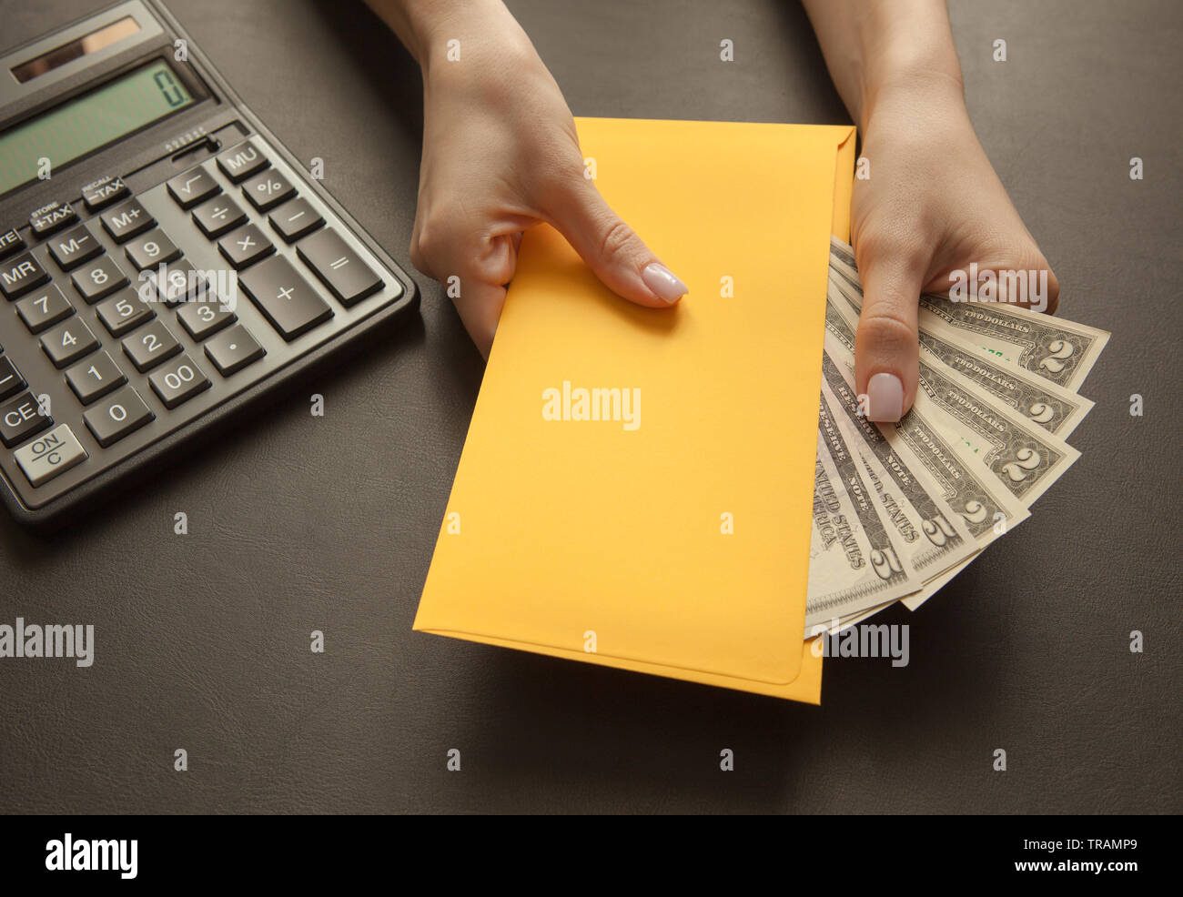Concepto de recibir el sueldo en un sobre. Sobre amarillo con dinero en una  mesa oscura Fotografía de stock - Alamy