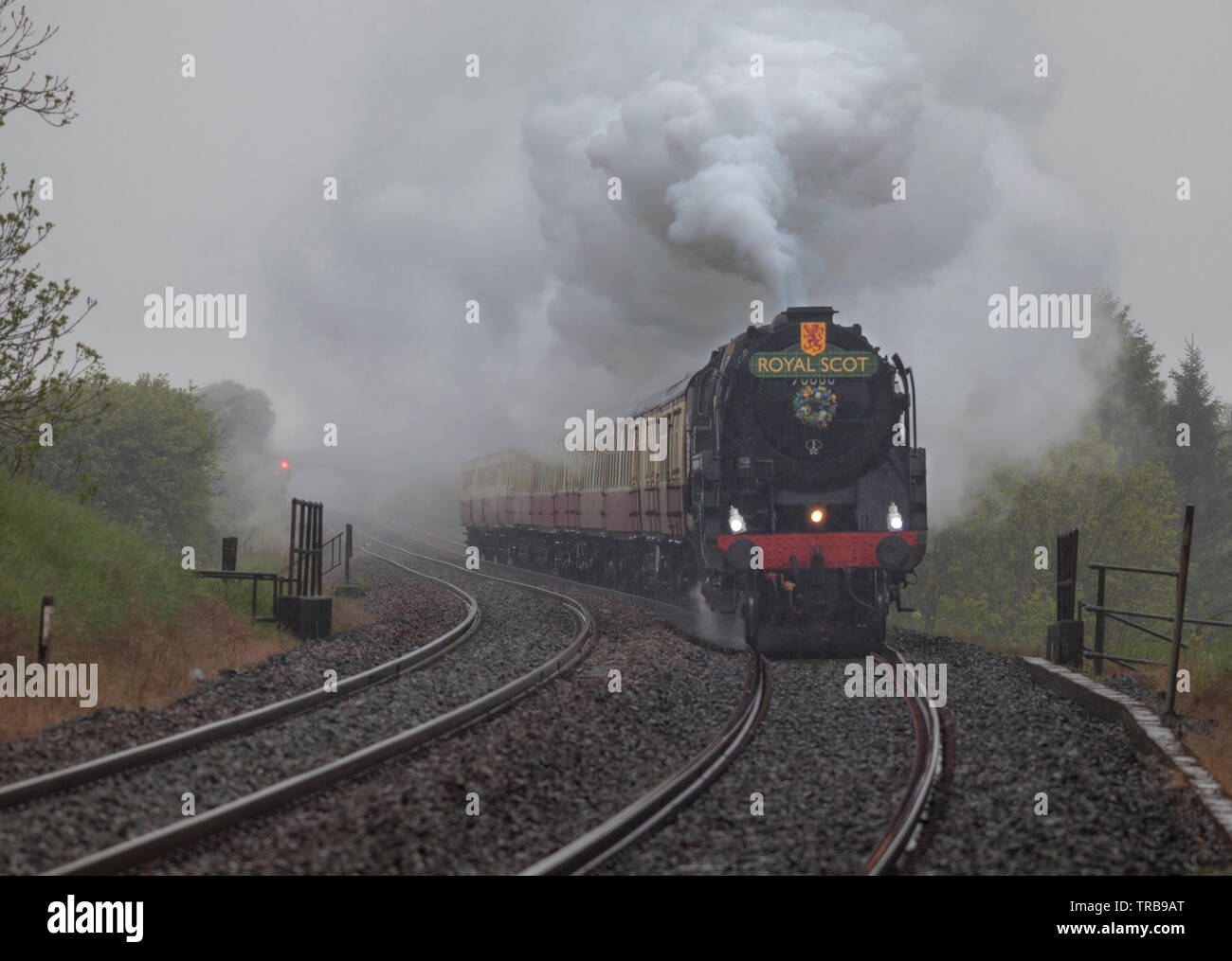 Locomotora de vapor 70000 Britannia pasando Horton en Ribblesdale en liquidar a Carlisle railway en Heavy Rain con sapos railtour Foto de stock