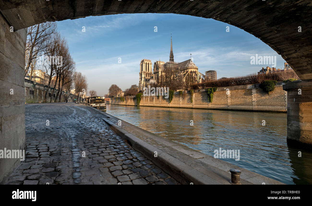 Por la mañana la vista de la catedral de Notre Dame, París, Francia, durante el invierno desde el terraplén del río Sena con el puente. Foto de stock