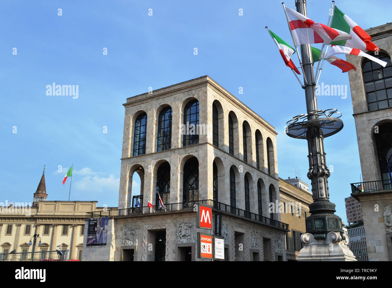 Milan/Italia - Junio 1, 2015: Vista del Palacio Real, el museo del siglo XIX y un mástil con banderas en la plaza del Duomo en un día soleado de verano. Foto de stock