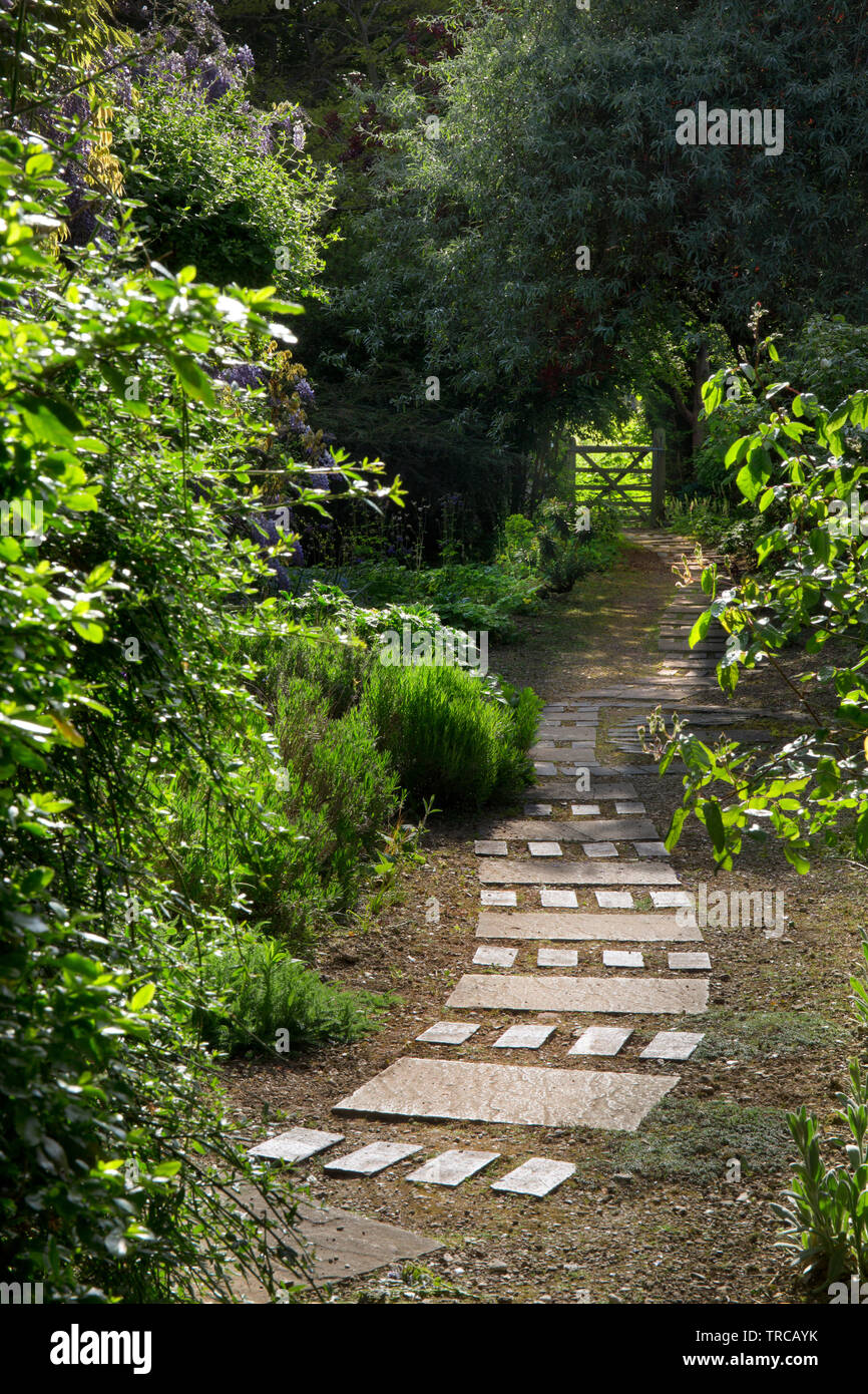 Ladrillo y camino de gravilla inset en grava en el jardín inglés, Inglaterra Foto de stock