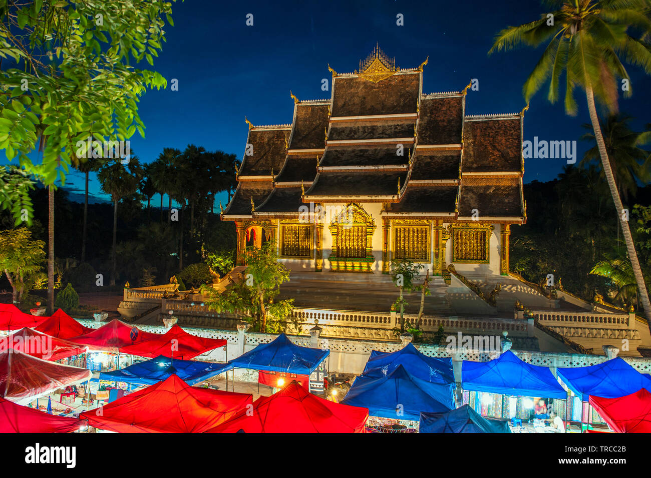 El mercado nocturno de Hmong con Haw Pha Bang templo en el fondo en el centro de Luang Prabang, una ciudad declarada Patrimonio de la humanidad en la República Democrática Popular Lao. Foto de stock
