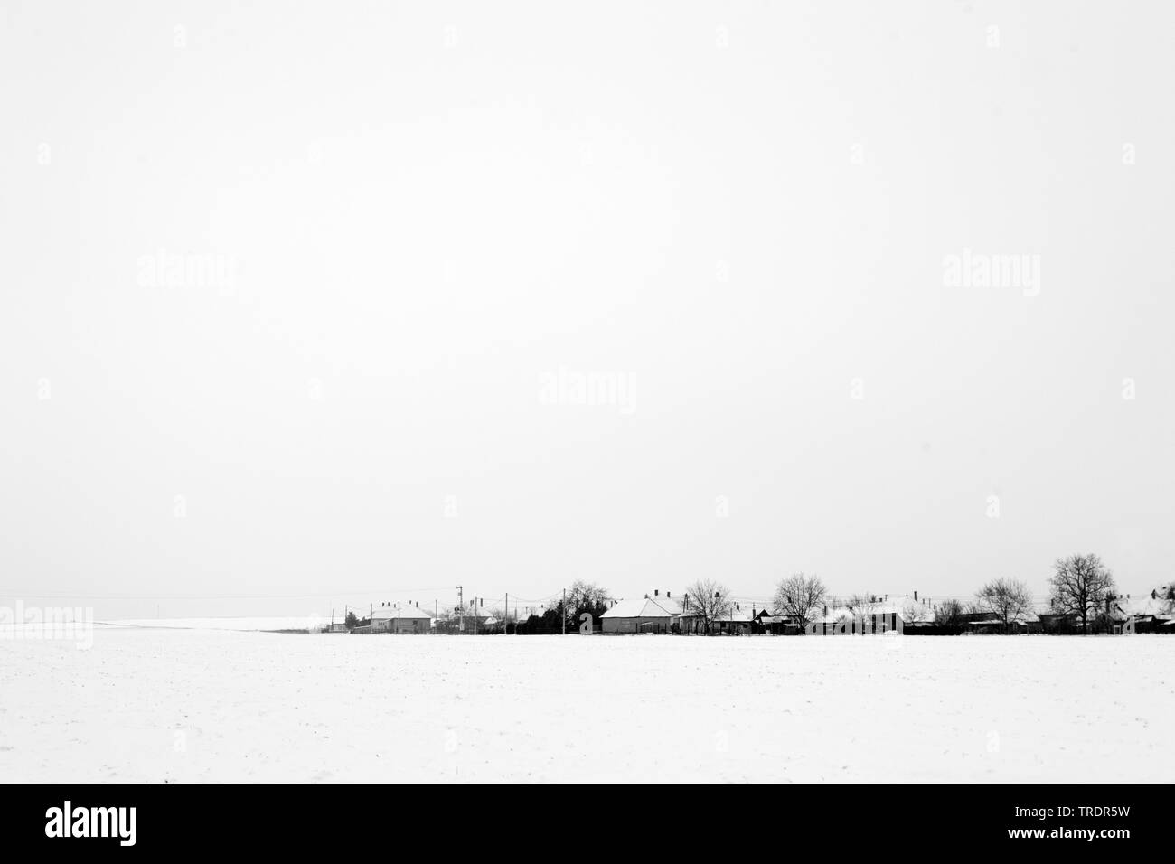 Paisaje invernal con pueblo en blanco y negro, Hungría Foto de stock