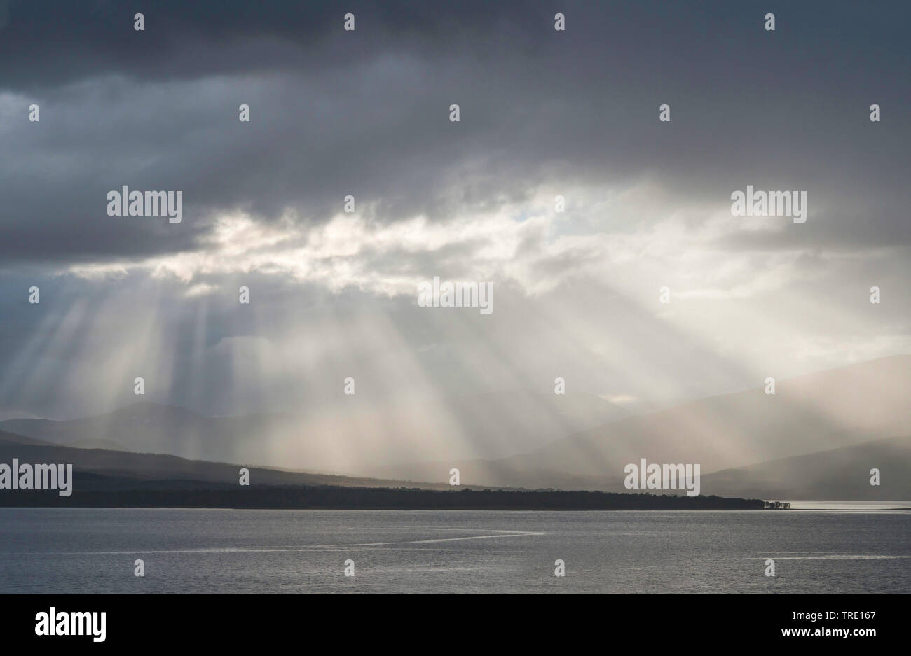 Rayos crepusculares rompiendo las nubes sobre isla Kvaloya, Noruega Troms, Tromsoe Foto de stock