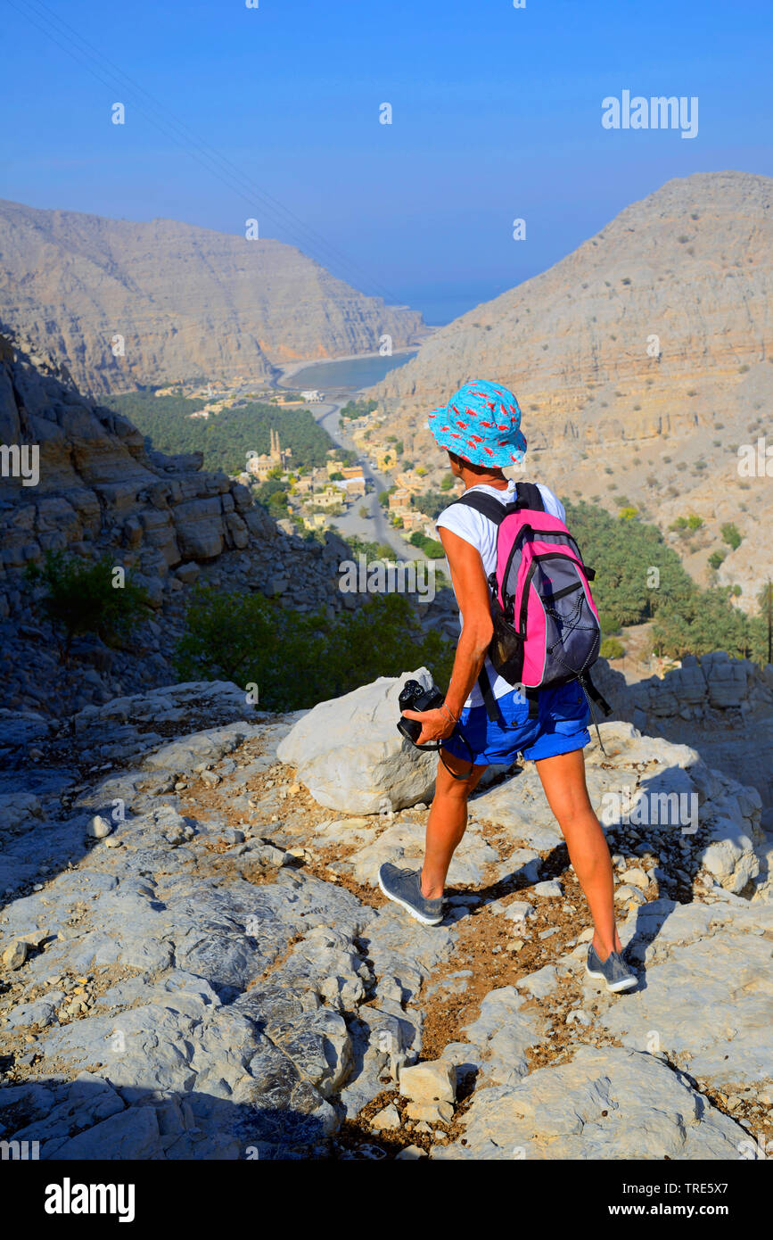 Wanderer femenino en las montañas cerca de la ciudad costera de al-Chasab , Omán Khasab Foto de stock