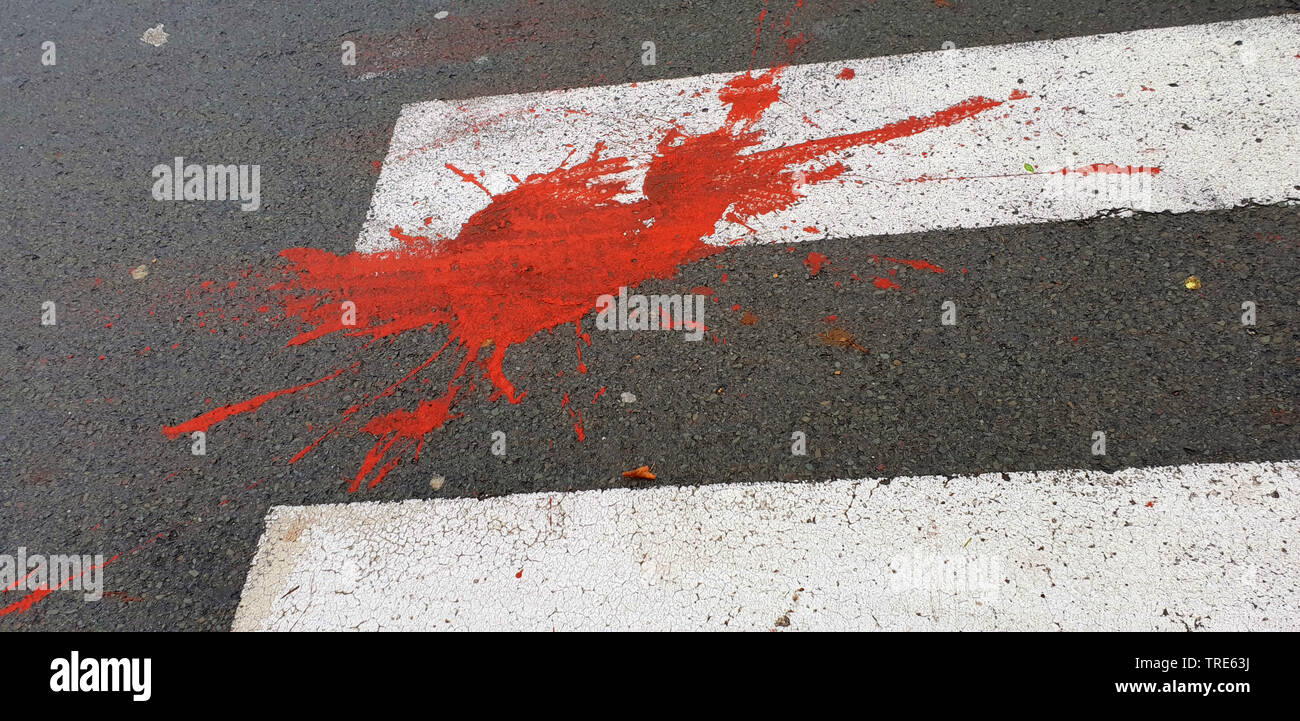 Mancha de pintura roja en un cruce de peatones imitando una mancha de sangre sangre, humor negro, Alemania Foto de stock