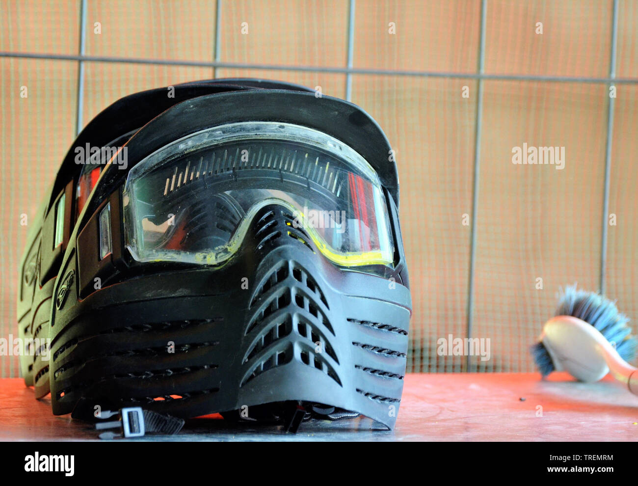 Equipo de Paintball. Un casco protector, completado con una máscara para  proteger la cara, listo para ser usado para la batalla. Junto al cepillo  para quitar la pintura res Fotografía de stock -