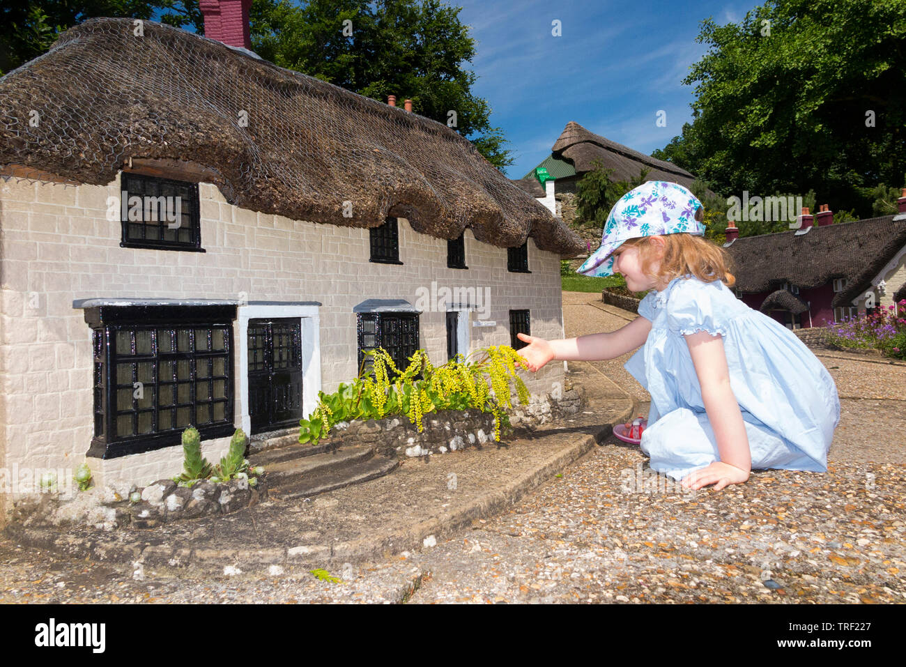 Niña / niña / niño / Niños / niño / niños explorar la aldea modelo en Godshill en la Isla de Wight, en un día soleado con el cielo azul / cielos. (99) Foto de stock