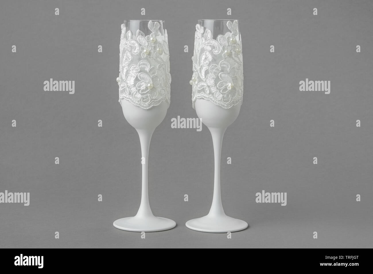 Dos copas de vino boda blanca decorada con encajes y perlas. Foto de stock