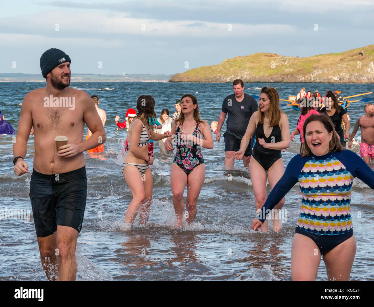 Loony Dook , el día de Año Nuevo: la gente valiente de agua fría, Firth of Forth, North Berwick, East Lothian, Escocia, Reino Unido. Las mujeres jóvenes en trajes de baño mirando frío Foto de stock
