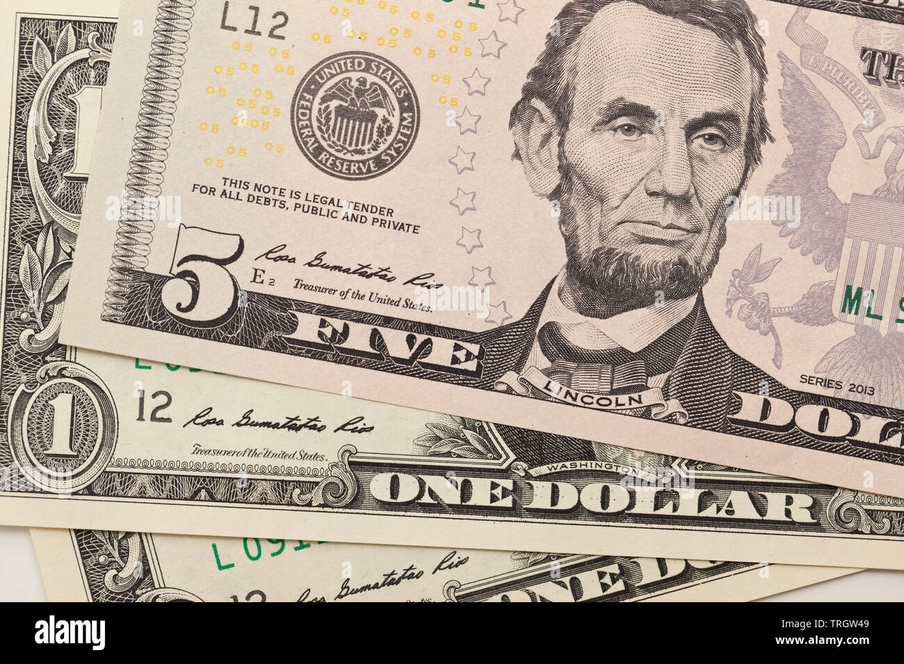 5 dollar bill con Abraham Lincoln y uno de los billetes de dólar Foto de stock
