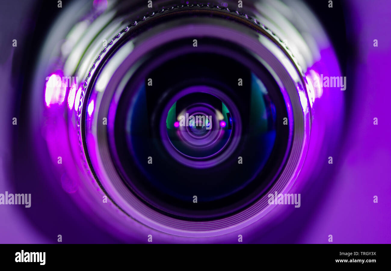 La lente de la cámara y una iluminación preciosa púrpura Foto de stock
