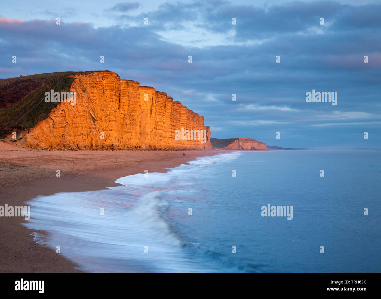 Olas rompiendo en la playa debajo de los acantilados, East West Bay, la Costa Jurásica, en Dorset, Inglaterra, Reino Unido. Foto de stock