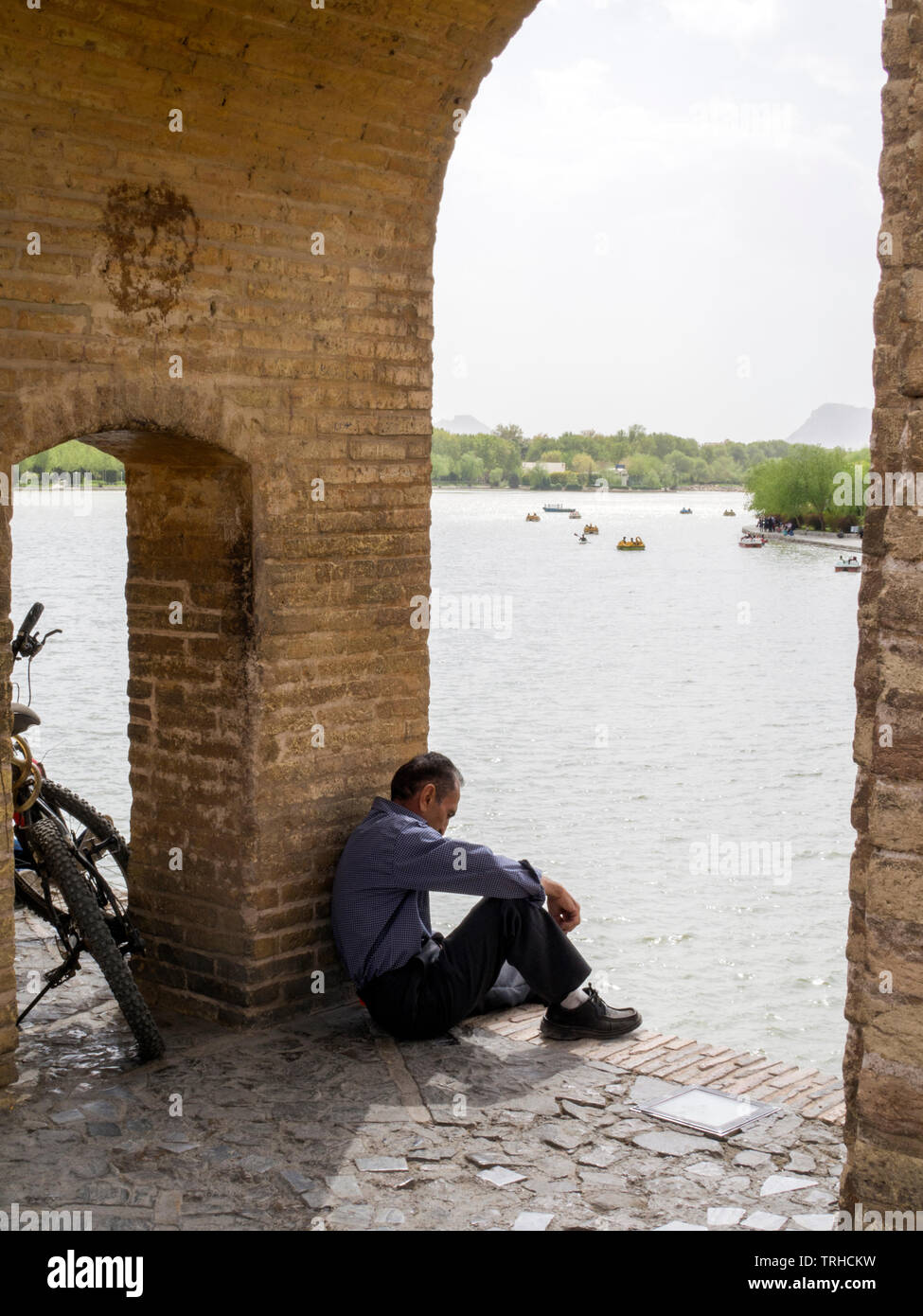 Un hombre Siosepol relajante junto al puente, construido en 1599, el puente más largo del río Zayanderud. Es uno de los ejemplos más famosos de Safavi Foto de stock
