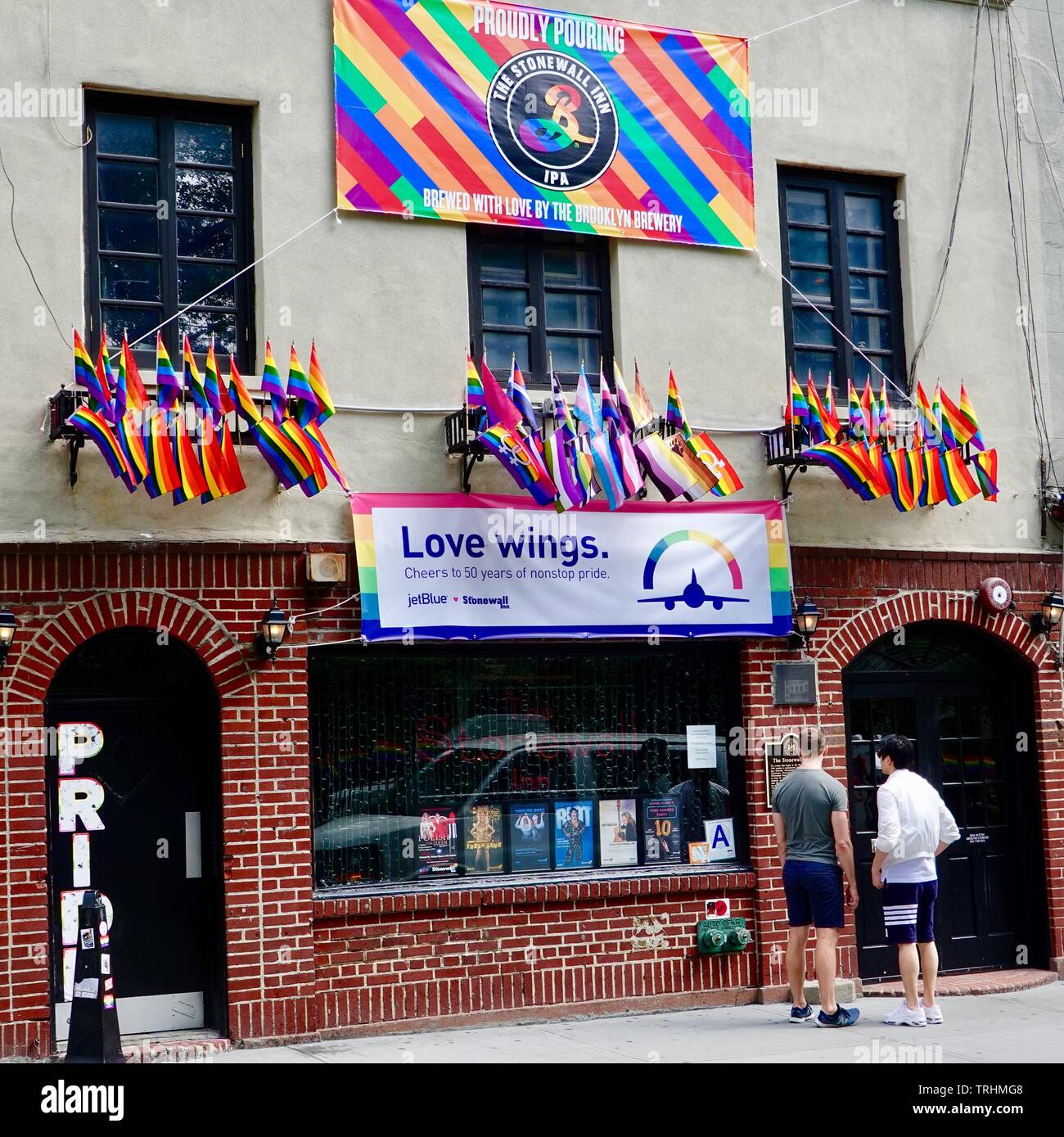 Pareja mirando la histórica placa en la parte delantera del Stonewall Inn, en Greenwich Village, Nueva York, NY, EE.UU. Foto de stock