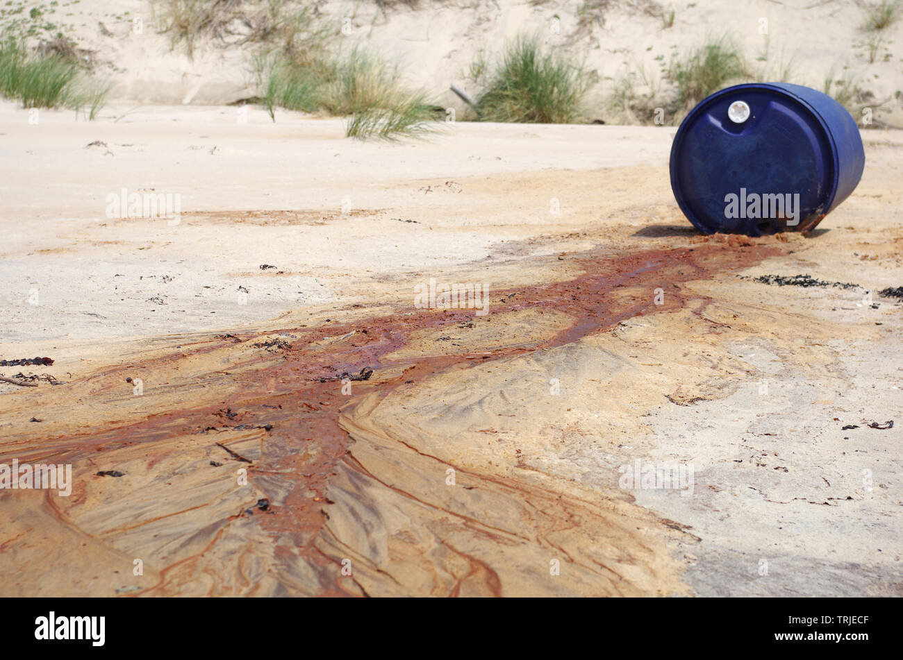 Los desechos tóxicos derramados en una playa Foto de stock
