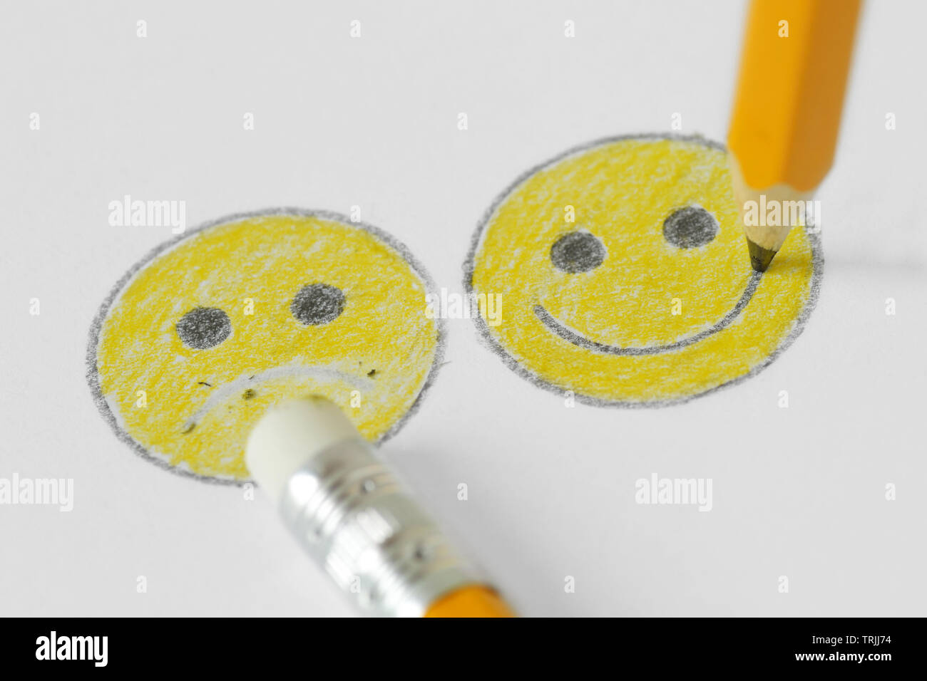 Dibujo de una cara sonriente con expresión positiva y negativa con lápiz y goma - Concepto de positividad Foto de stock