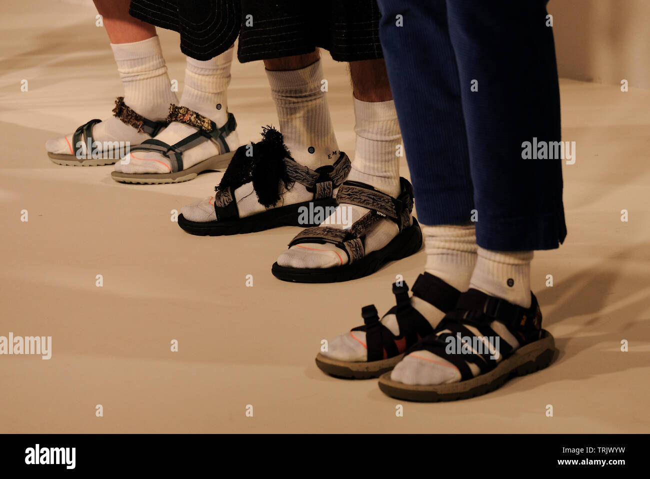 Tres modelos llevan sandalias y calcetines para la presentación de otoño de invierno de la diseñadora Tang durante la Semana la Moda de Londres el Salón de los