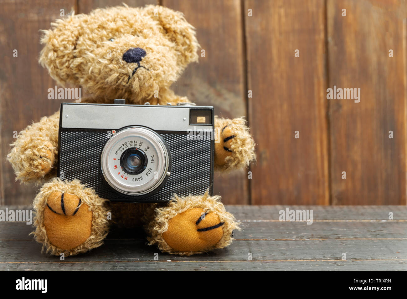 Oso de peluche marrón celebración antigua cámara de fotos retro sobre fondo  de madera Fotografía de stock - Alamy
